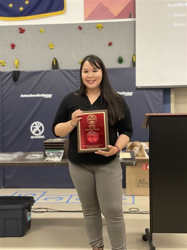 Teacher holding award 
