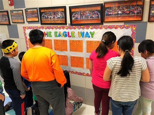 Students review the Positive Referral bulletin board 
