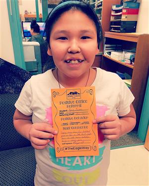 A student shows her Positive Referral slip 