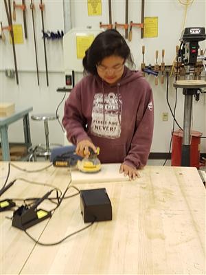 Girl using a disc sander. 