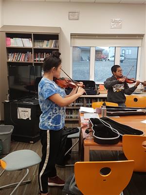 2 students practicing the violin  