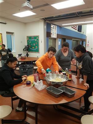 students mixing a big bowl of bread batter  