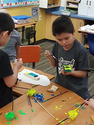 Elementary student painting pinewood derby car  