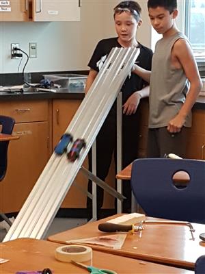 2 boys testing their pinewood derby cars 