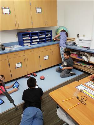 3 students playing tag with their robots 