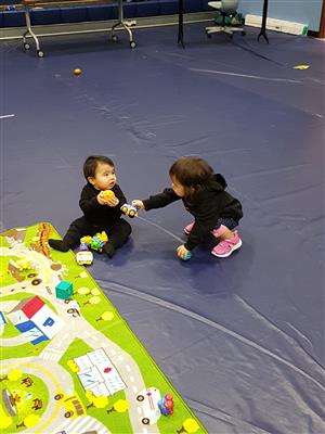 2 small children playing with toys 