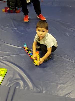 little boy playing with a Lego train  