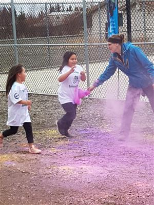 Girls running through colored powder  