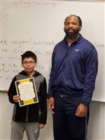 boy and teacher pose with certificate  
