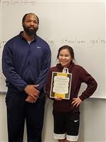 student and teacher pose with award  