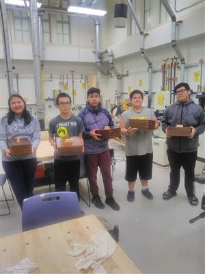 5 shop students holding the jewelry box they made  