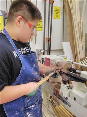 student working on a wood lathe  