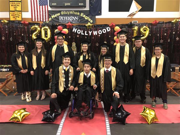  Group of 11 graduating seniors in front of Hollywood themed graduationd decorations.
